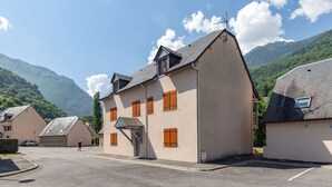 Un bâtiment doté d’un toit en pente, de nombreuses fenêtres et d’une antenne visible.