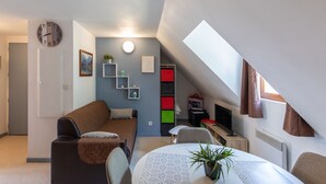 Un espace de vie compact comprenant un canapé, une table à manger et un téléviseur.