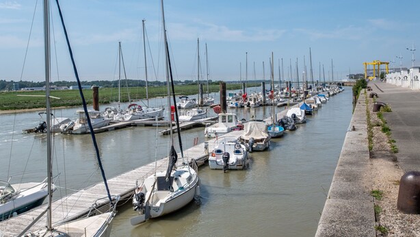 A marina with boats docked along a concrete quay, a clear sky, and a grassy area in the background. - Chez Cathy - Cocon pour 2 à 15 min de la plage (Etaples-sur-Mer)