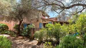 A rustic building with a garden path, a wooden gate, and a hammock. - Maison Agosta Plage - Pour 5 à 500 m de la plage (Albitreccia)