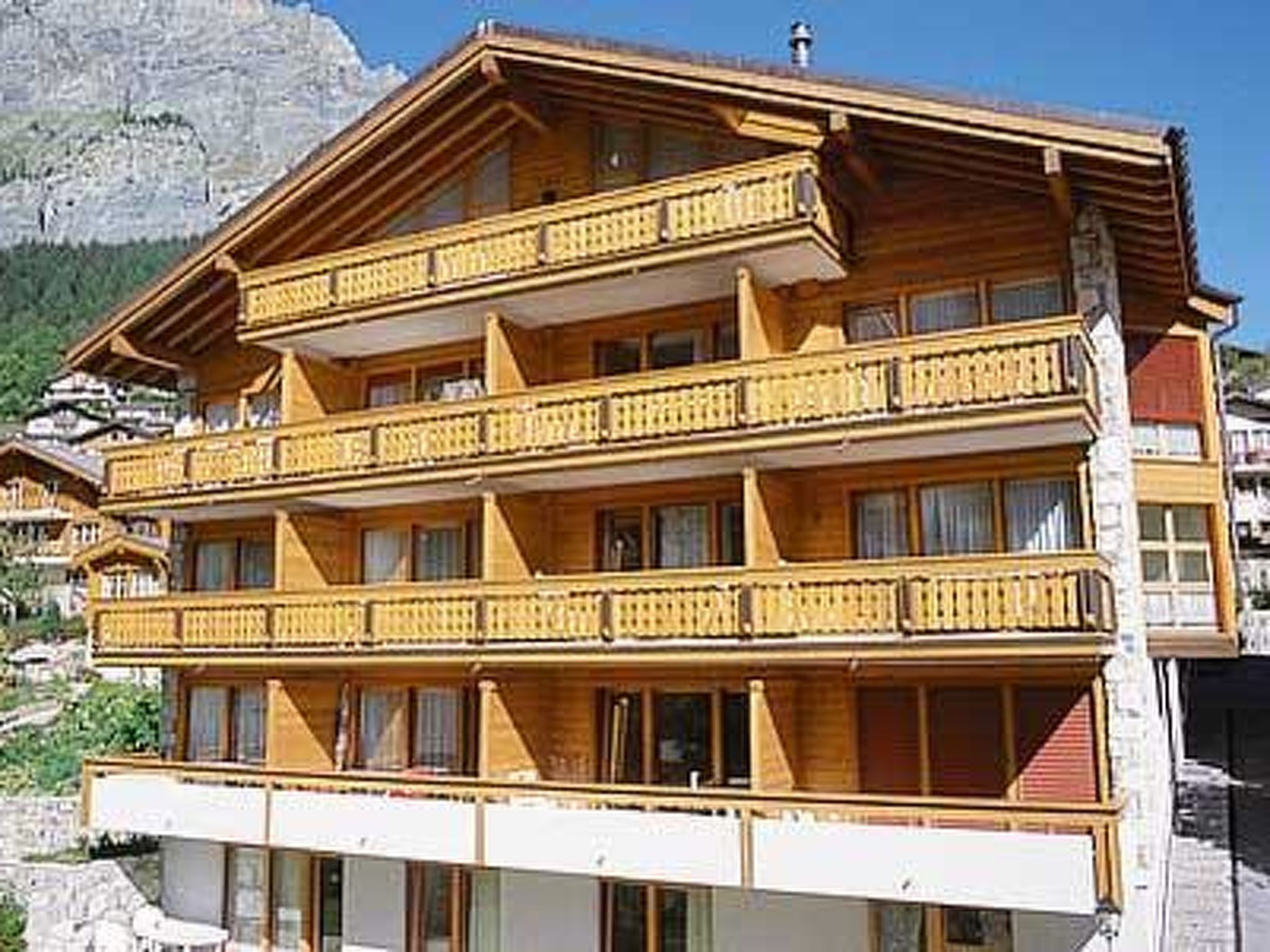 A multi-story wooden building with balconies, likely a hotel or guesthouse.