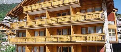 A multi-story wooden building with balconies, likely a hotel or guesthouse.