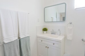 Een haardroger, handdoeken, zeep, toiletpapier