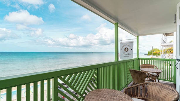 Un balcone con mobili in vimini che si affaccia su una spiaggia.