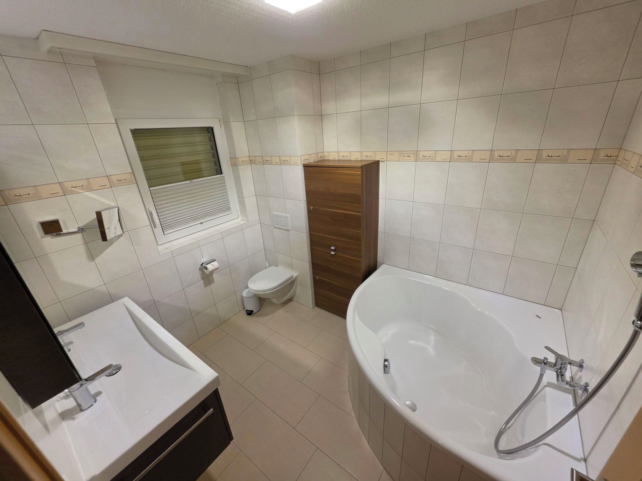 Une salle de bain avec un lavabo, des toilettes et une baignoire, le tout de couleur blanche.