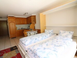 A compact room with a bed, a small table, and a kitchenette. - Adlerhorst Leukerbad # 2-bed apartment, Dusche, WC by Interhome (Leukerbad)
