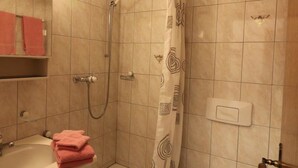 Un baño con ducha, bañera y toallero.