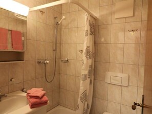 Ein Badezimmer mit Dusche, Badewanne und Handtuchhalter.