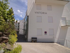 En byggnad som heter ”VIKTORIA”, med en skylt som förbjuder parkering, en liten vagn och en grind vid ingången.