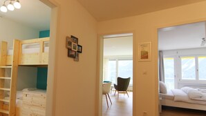 A room with a bunk bed, a desk, and a chair. There is a window with a view of the outdoors. - Viktoria B16 by Arosa Holiday Appartement/Fewo, Dusche oder Bad, WC, 4-Bettwohnu by Interhome (Arosa)