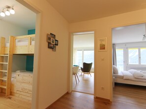 Ett rum med en våningssäng, ett skrivbord och en stol. Det finns ett fönster med utsikt över omgivningen.