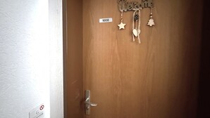 Una puerta de madera con un letrero decorativo que dice 'Welcome' y un cartel pequeño con el número '1808'.