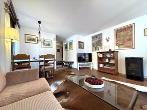 A living room with a sofa, a coffee table, a fireplace, and a bookshelf. - Lärchenwald 1808 # 4-bed apartment, Bad, WC 4-Bettwohnung, Bad, WC by Interhome (Leukerbad)