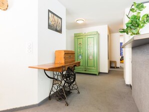 Ein Zimmer mit einem Holztisch, grünen Schränken und einer Pflanze.