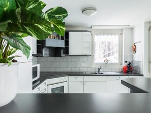 Eine moderne Küche mit weißen Schränken, einer schwarzen Arbeitsplatte und einem Fenster mit Blick.