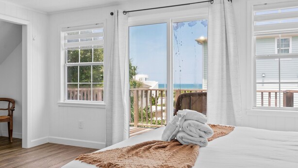 Ein Schlafzimmer mit großem Bett, Meerblick und einem Balkon.
