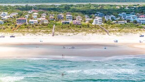 Eine Küstenlandschaft mit Strandhäusern, einem Sandstrand und dem Meer.