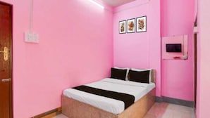 A pink room with a bed, a small TV, and three framed pictures on the wall. - Hotel O Adamas University Barasat (Barasat)