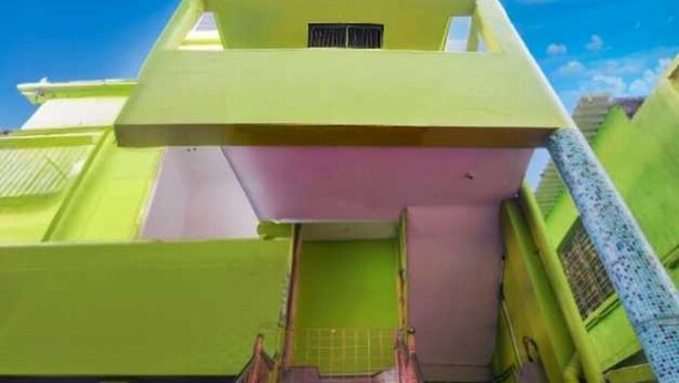 A multi-story building with a flat roof, a central entrance, and a visible window on the upper floor. - Hotel O Adamas University Barasat (Barasat)