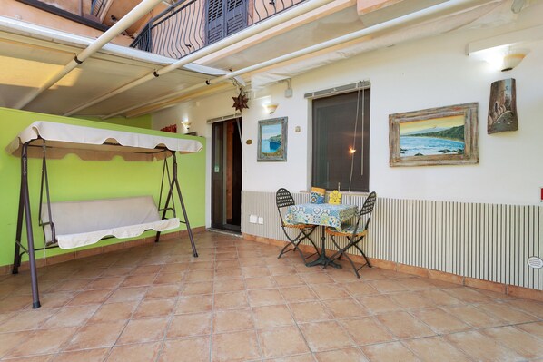 A room with a bench, a table with chairs, a window with a view, and a door. - Apartment 'Le Grand Soleil - Albatros' with Sea View, Wi-Fi and Air Conditioning (Taormina)