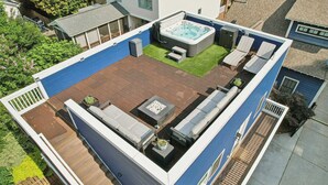 A rooftop deck with a hot tub, seating area, and a fire pit. - Loft Haven Rooftop Terrace (Charlotte)