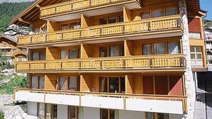 En flervåningsbyggnad i trä med balkonger, troligen ett hotell eller pensionat.
