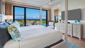 A bedroom with a large bed, a TV, a dresser, and a view of the ocean. - Hali'a Mai Distant Ocean View Koloa Home w/ Pool (Koloa)