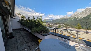 A balcony with a table and chairs, overlooking a mountainous landscape with a town in the distance. - Lorez 5D by Arosa Holiday Appartement/Fewo,  , 2-Bettwohnung Lorez 5D by Interhome (Arosa)