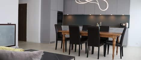 Ein modernes Wohnzimmer mit einer Couch, einem Couchtisch und einem Essbereich mit Tisch und Stühlen.