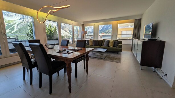 A modern hotel room with a dining area, a sofa, and a TV. - Lorez 5D by Arosa Holiday Appartement/Fewo,  , 2-Bettwohnung Lorez 5D by Interhome (Arosa)