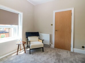Ein Zimmer mit Heizkörper, Holztür und Stuhl.