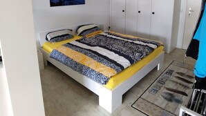 A bedroom with a bed, wardrobe, and a painting on the wall. - Valère C 222 # 2-bed apartment, Dusche, WC 2-Bettwohnung, Dusche, WC by Interhome (Leukerbad)
