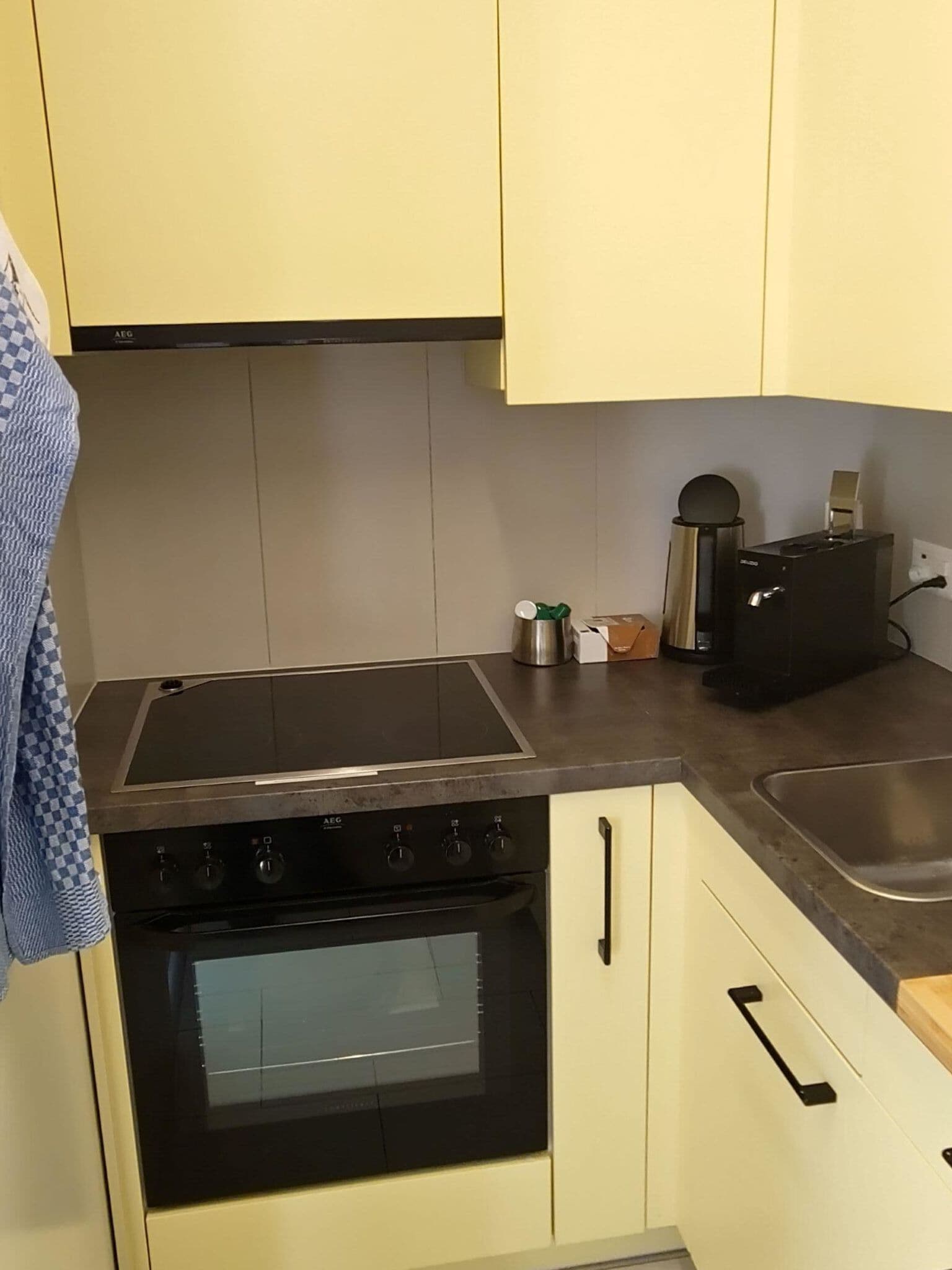 A kitchen with a stove, oven, and a coffee maker.