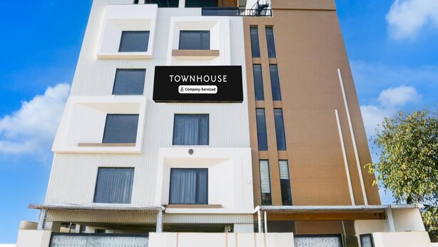 A multi-story building with a sign reading 'TOWNHOUSE Company Serviced.' - Premium Townhouse Majra Isbt Dehradun (Dehradun)