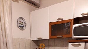 A kitchen with white cabinets, a microwave, and a flower arrangement on the counter.