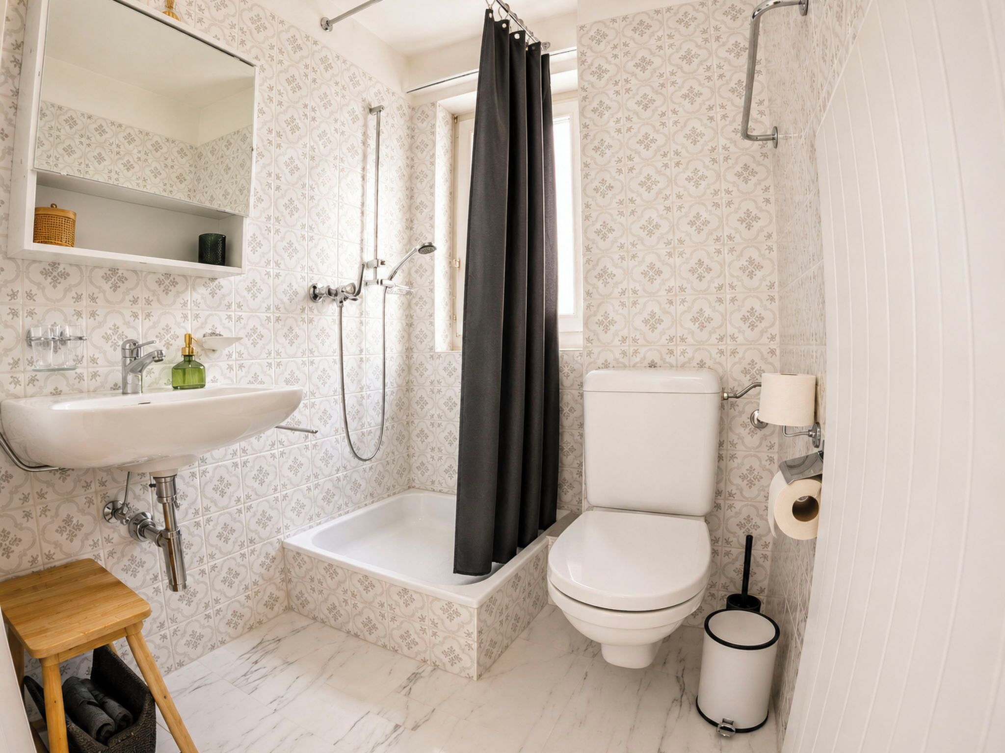 A bathroom with a white sink, a bathtub, a toilet, and a shower curtain.