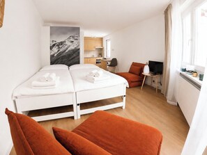 A hotel room with a bed, a desk, a chair, and a TV. - Majesta Leukerbad # 2-bed apartment, Dusche, WC by Interhome (Leukerbad)