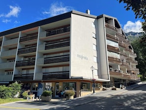 A multi-story building with balconies, a sign reading 'majesta,' and a street in front. - Majesta Leukerbad # 2-bed apartment, Dusche, WC by Interhome (Leukerbad)