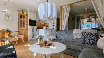 Una sala de estar moderna con un sofá, una mesa de centro y un comedor con un mueble de madera.