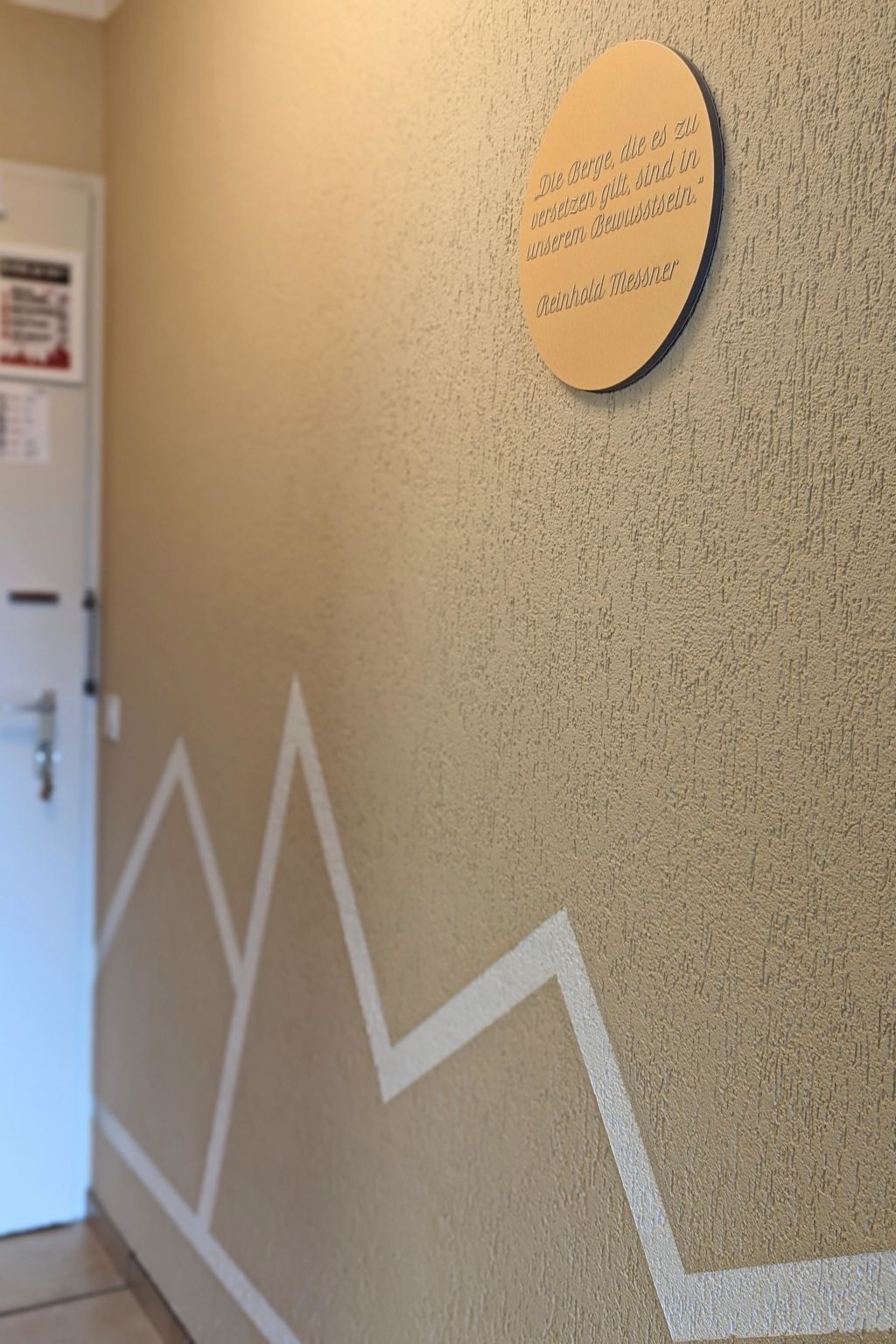 A wall with a circular plaque and a zigzag pattern.