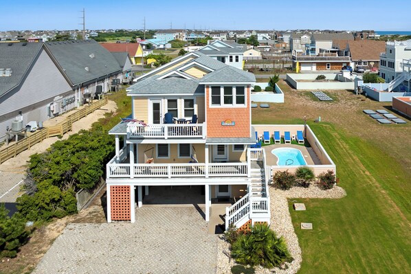 Une maison à deux étages avec un balcon, une piscine et une cour clôturée.