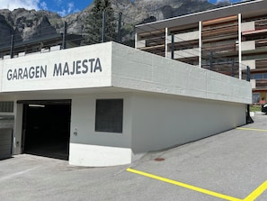 A parking garage entrance labeled 'GARAGEN MAJESTA' with a concrete exterior and a metal railing. - Majesta Leukerbad # 3-bed apartment, Dusche, WC by Interhome (Leukerbad)