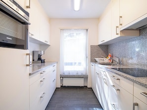 A modern kitchen with white cabinetry, a granite countertop, a Siemens microwave, and a built-in coffee machine. - Gentiana B-2 by Arosa Holiday Appartement/Fewo,   Gentiana B2 by Interhome (Arosa)