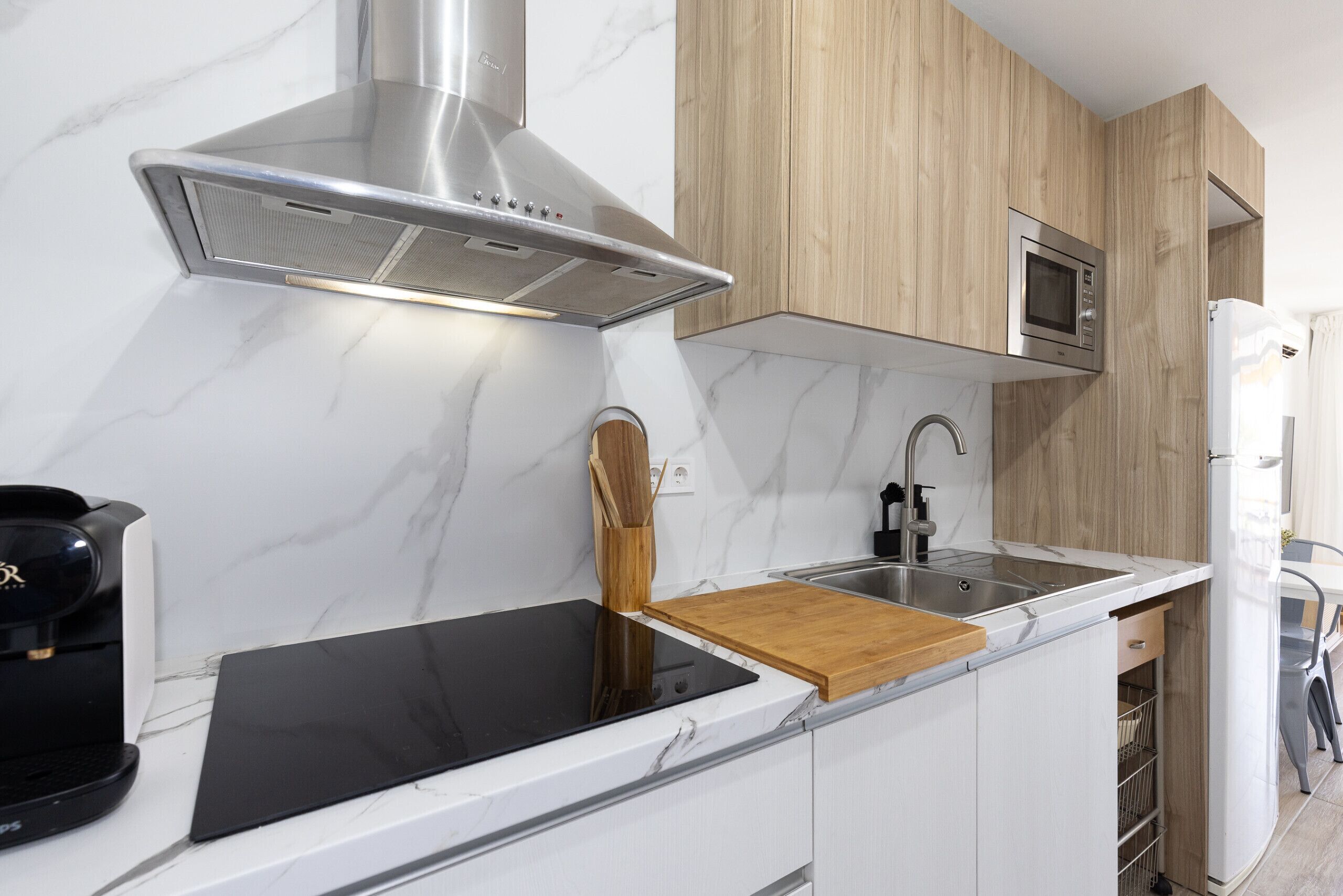 A modern kitchen with a built-in stove, microwave, and stainless steel range hood.