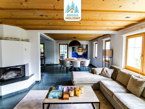 Ein modernes Interieur mit Kamin, Essbereich und einer Couch.