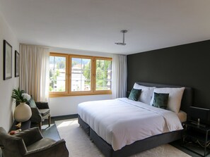 Ein modernes Schlafzimmer mit einem großen Bett, einem Schreibtisch und einem Stuhl.