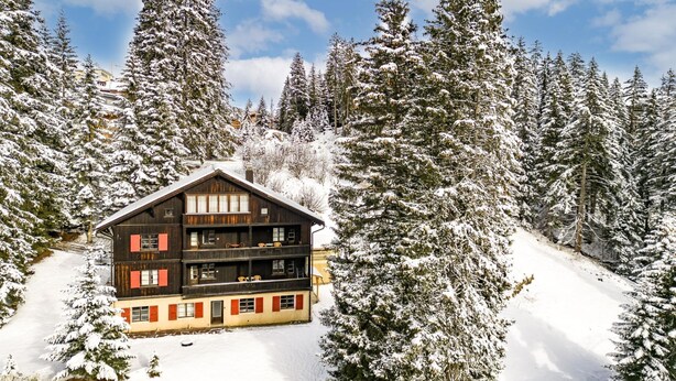 A wooden chalet with multiple balconies, surrounded by snow-covered trees. - Pradella 2 by Arosa Holiday Studio, Dusche und Badewanne, 4-Bettwohnung by Interhome (Arosa)