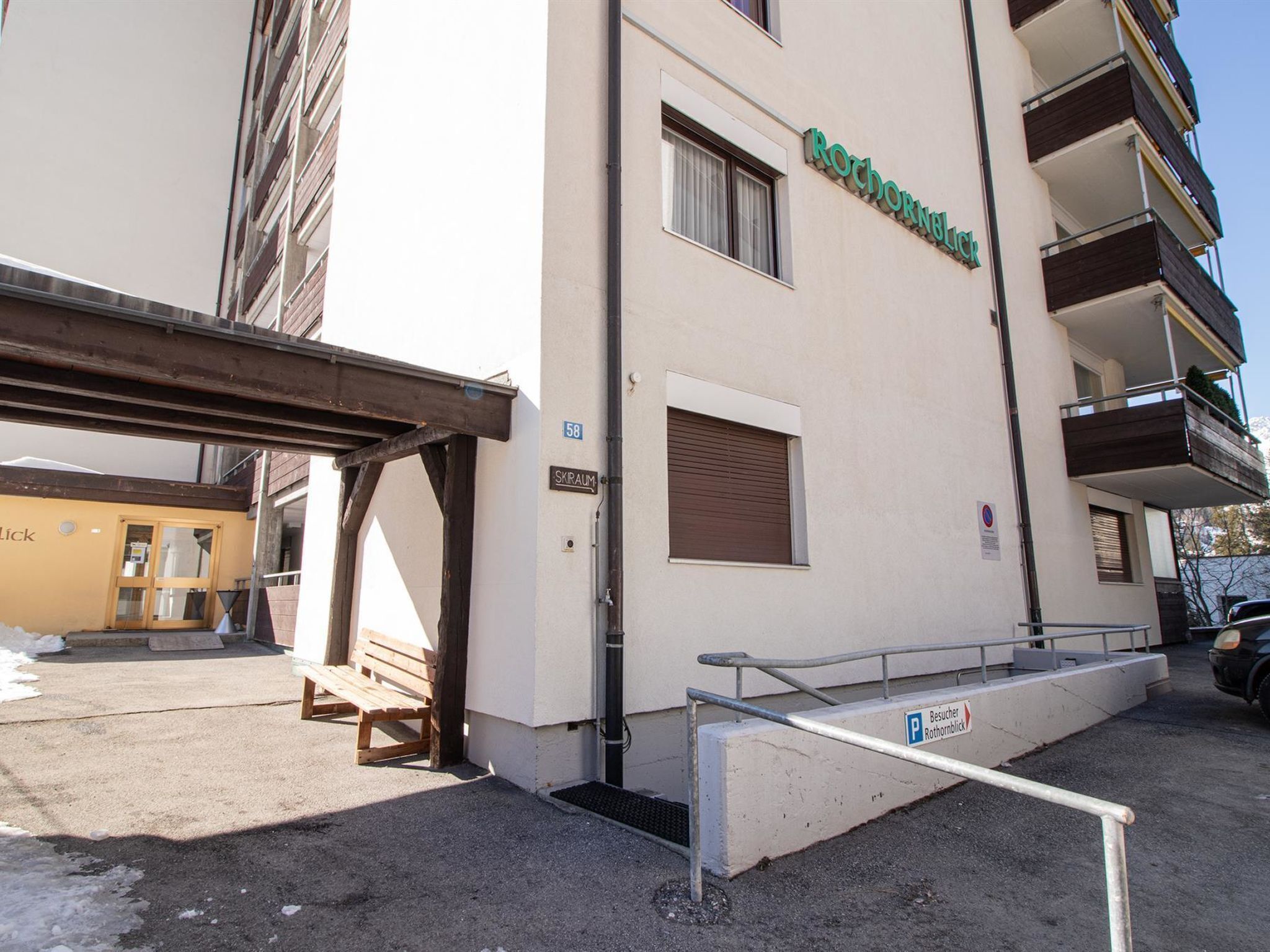 Un bâtiment avec une enseigne indiquant « Rochorentalblick » et une entrée bien visible, dotée d’une rampe.