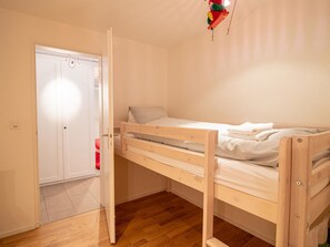 Ein Schlafzimmer mit Etagenbett, einer Tür und einer Pendelleuchte.