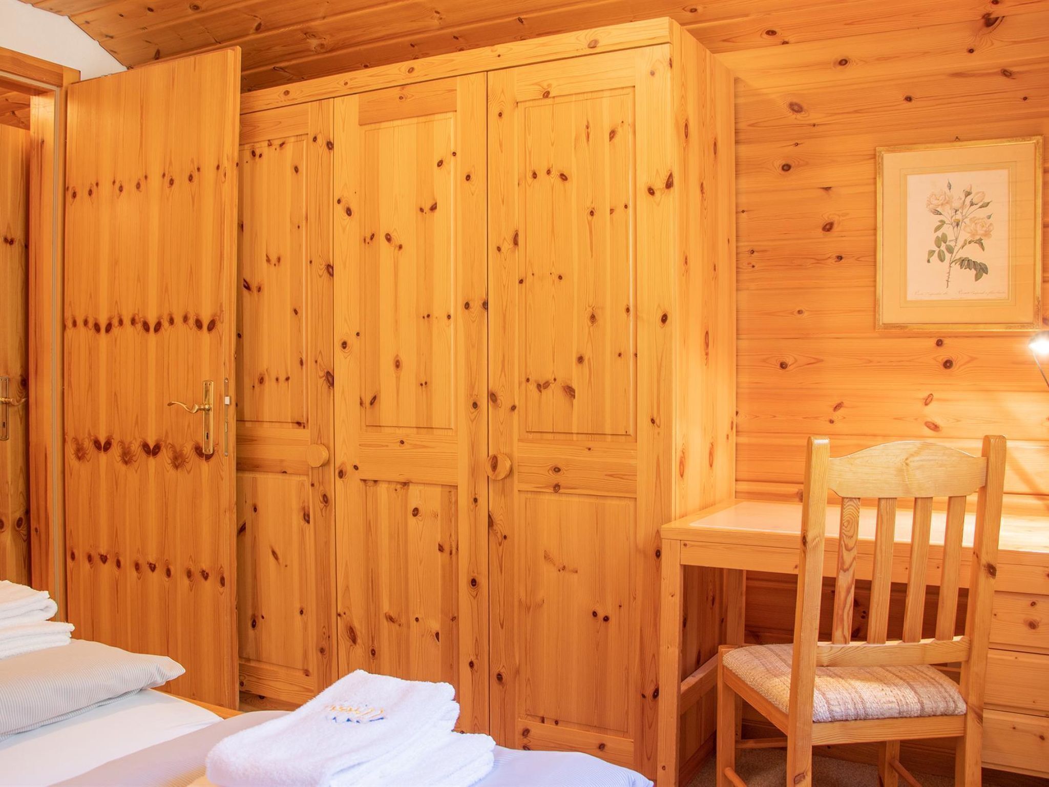 Une pièce en bois avec un lit, un bureau et une chaise.